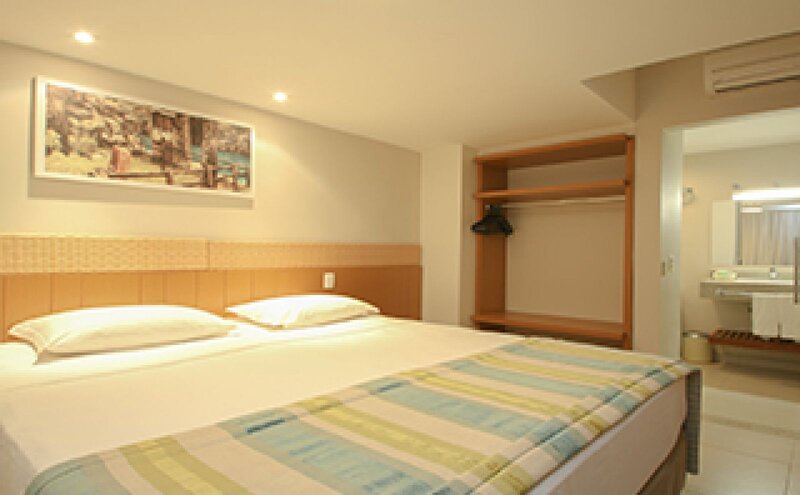 Quarto de casal com cama ampla e decoração clara